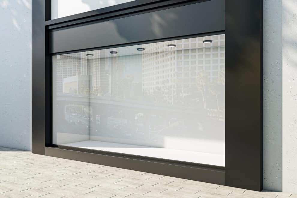 Sprzątanie sklepów - profesjonalne przygotowanie lokali usługowych 3 Perspective View On Blank Light Wall Background In Empty Shop Window With Space For Your Product Presentation Behind Glass Walls With City Reflection In Modern Building Outdoors. 3d Rendering, Mockup