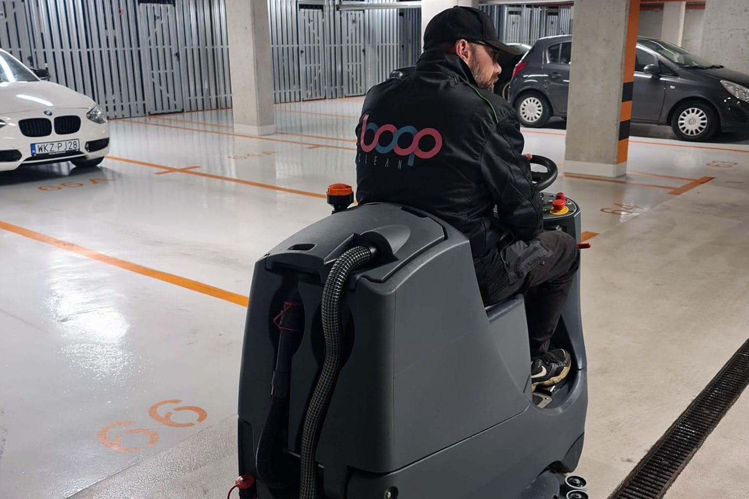 Pracownik BOGOclean na maszynie szorująco-zbierającej w garażu podziemnym